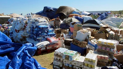 In this Wednesday, Sept. 14, 2016, photo, a volunteer sorts through donated food near the Standing Rock Sioux Reservation in North Dakota. Tribal officials say donated food and clothing has come from around the world to support those opposing the $3.8 billion Dakota Access pipeline.