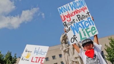 Tusweca Mendoza, 10, of Arlington, Va., originally from Pine Ridge, S.D., holds up a sign outside U.S. District Court in Washington, Tuesday, Sept. 6, 2016, as members of the Standing Rock Sioux Tribe have asked a federal judge to temporarily stop work on parts of the Dakota Access Pipeline to prevent the destruction of sacred and culturally significant sites near Lake Oahe.