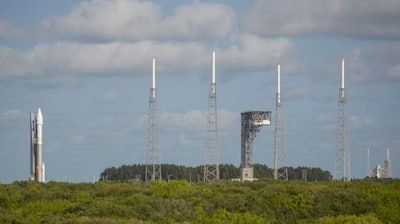 In this Wednesday, Sept. 7, 2016 photo, a United Launch Alliance Atlas V rocket, left, carrying NASA's OSIRIS-REx spacecraft, sits at its launchpad at Cape Canaveral Air Force Station in Florida. The mission, scheduled to launch on Thursday, Sept. 8, is the first U.S. attempt to reach an asteroid return a sample to Earth for study.
