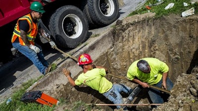 Crews break ground and work to remove and replace lead-tainted pipes from three homes during first day of the second phase under Mayor Karen Weaver's Fast Start program Wednesday, Aug. 31, 2016, in Flint, Mich. The program was launched in March and has replaced infrastructure at over two dozen Flint homes. There are an estimated 250 homes pegged to have service lines replaced during the program's second phase.