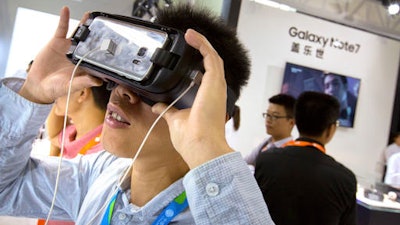 A visitor tries out a Samsung Gear VR headset at a Samsung Electronics display booth during an electronics expo in Beijing, Wednesday, Sept. 21, 2016. Samsung Electronics says its smartphones sold in China don't suffer the same problems as units that caught fire in the United States but Chinese customers complain the company is doing too little to reassure Chinese owners their handsets are safe.
