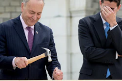House Speaker Paul Ryan of Wis., right, hides his face and laughs at Sen. Charles Schumer, D-N.Y., bends his nail during a ceremony to drive in the first nails to signifying the start of construction on the 2017 presidential inaugural platform, Wednesday, Sept. 21, 2016, on Capitol Hill in Washington.
