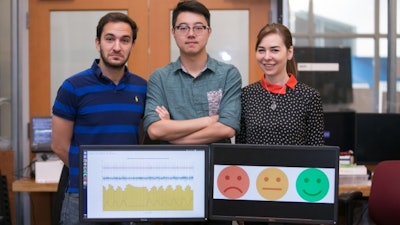 Left to right: PhD student Fadel Adib, PhD student Mingmin Zhao, and Professor Dina Katabi pose with their EQ-Radio device, which can detect emotion using wireless signals.