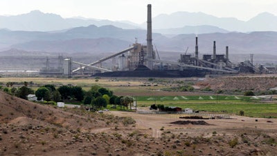 In this May 14, 2012 file photo, the Reid-Gardner power generating station is seen near a farm on the Moapa Indian Reservation in Moapa, Nev. America has quietly but significantly shifted how and where it gets its energy during Barack Obama’s presidency, slicing the nation’s pollution of gases that are warming Earth. But experts say it is nowhere near enough and the president deserves only partial credit for an energy revolution.