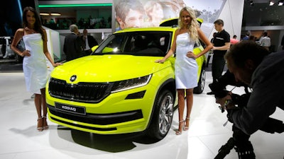 Models pose next to the Skoda Kodiak 4 X 4 at the Paris Motor Show in Paris, France, Thursday, Sept. 29, 2016. Many major automakers are finding the Paris auto show, held in a city whose mayor wants to ban diesels to reduce pollution, as a fine place to show off new zero-emission electric cars.