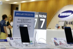 In this Sunday, Sept. 11, 2016 file photo, customers wait for recall of their Samsung Electronics Galaxy Note 7 smartphones as powered-off Galaxy Note 7 smartphones are displayed at the company's service center in Seoul, South Korea. Samsung on Tuesday, Sept. 13, 2016, plans to issue a software update for its recalled Galaxy Note 7 smartphones that will prevent them from overheating by limiting battery recharges to under 60 percent.