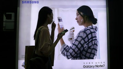 In this Sept. 10, 2016, file photo, a woman walks by an advertisement of the Samsung Electronics Galaxy Note 7 smartphone at a subway station in Seoul, South Korea. South Korea's government asked Samsung Electronics to extend the refund period for its Galaxy Note 7 smartphones that have been subject to an unprecedented global recall.