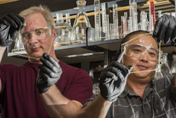 Sandia National Laboratories researchers Cy Fujimoto, right, and Michael Hibbs demonstrate the clarity of their recent membranes.