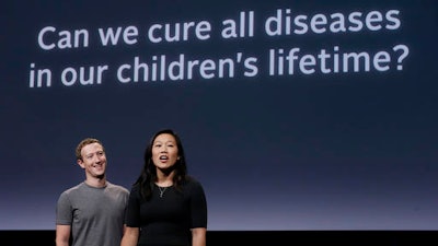 In this Tuesday, Sept. 20, 2016, photo, Facebook CEO Mark Zuckerberg and his wife, Priscilla Chan, prepare for a speech in San Francisco. Zuckerberg and Chan have a new lofty goal: to cure, manage or eradicate all disease by the end of this century. To this end, the Chan Zuckerberg Initiative, the couple's philanthropic organization, is committing significant financial resources over the next decade to help accelerate basic science research.