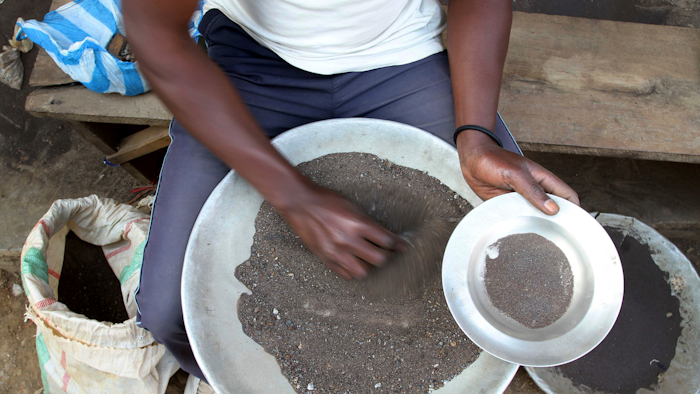 In this file photo a Congolese miner sifts through ground rocks to separate out the cassiterite, the main ore that’s processed into tin, in the town of Nyabibwe, eastern Congo.