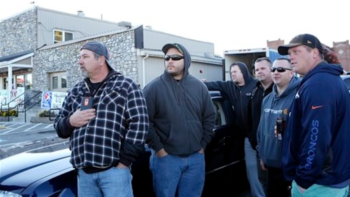 Norfolk Southern employees wait down the road to be let into work, as the company placed a hold on entering the railyard, after the shooting at FreightCar America Tuesday morning, Oct. 25, 2016. Police say a man fatally shot someone and wounded several others inside FreightCar America, a rail car manufacturing company, before apparently killing himself.