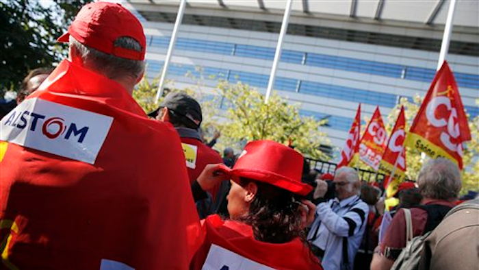 In this Tuesday, Sept. 27, 2016 file photo, Alstom employees stage a protest in front of its headquarters in St Ouen, north of Paris, asking not to close a plant in Belfort, eastern France, which employs 400 people. France's government is expected to present its plan to save a historic train-making site of manufacturer Alstom, in a bid to save jobs ahead of presidential elections.