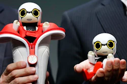 Toyota Motor Corp. SMO Moritaka Yoshida, right, and Fuminori Kataoka, project general manager from Toyota Motor Corp., pose for photographers with compact sized humanoid communication robots, Kirobo Mini, during a press unveiling in Tokyo. The new robot from Japanese automaker Toyota Motor Corp. can’t do much else but chatter in a high-pitched voice.