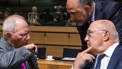 German Finance Minister Wolfgang Schauble, left, talks with Franch Finance Minister Michel Sapin, right, and European Commissioner for Economic Affairs, Taxation and Customs Pierre Moscovici during an EU finance ministers meeting at the EU Council in Luxembourg.