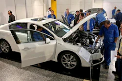 Iranian car workers inspect a Peugeot 508 at Iran Khodro car factory plant in Tehran, Iran, Wednesday, Oct. 5, 2016. Peugeot Citroen PSA has reached a deal with Iran's biggest carmaker to open a plant producing 200,000 vehicles a year, renewing an old partnership with Iran Khodro Co following the lifting of international sanctions. The two companies showcased five models to be produced by IKAP, a joint venture first announced in January during a visit to France by Iranian President Hassan Rouhani.
