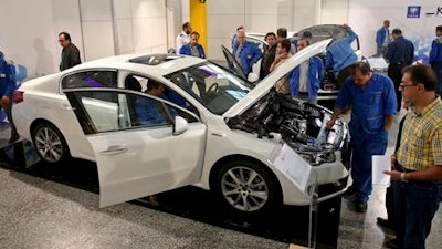 Iranian car workers inspect a Peugeot 508 at Iran Khodro car factory plant in Tehran, Iran, Wednesday, Oct. 5, 2016. Peugeot Citroen PSA has reached a deal with Iran's biggest carmaker to open a plant producing 200,000 vehicles a year, renewing an old partnership with Iran Khodro Co following the lifting of international sanctions. The two companies showcased five models to be produced by IKAP, a joint venture first announced in January during a visit to France by Iranian President Hassan Rouhani.