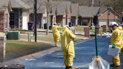 In this April 1, 2013 file photo, crews work to clean up oil in a Mayflower, Ark., neighborhood after an oil pipeline ruptured and spewed oil over lawns and roadways. Attorneys for landowners along the crude oil pipeline that ruptured in 2013 are asking a federal appeals court to reinstate their case. Landowners sued Exxon Mobil Pipeline Co., in 2013, alleging a breach of contract, but the case was dismissed in 2015.