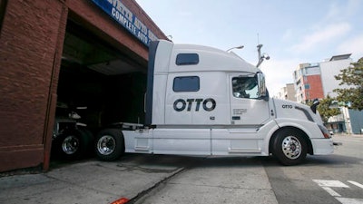 One of Otto's self-driving, big-rig trucks leaves the garage for a test drive during a demonstration at the Otto headquarters in San Francisco. Anheuser-Busch announced that it teamed up with Otto for a 120-plus mile beer delivery that marked the world's first by a self-driving truck.