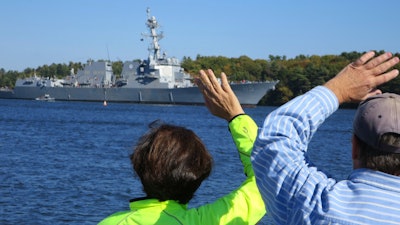 Spectators wave as the future USS Rafael Peralta leaves Bath Iron Works for builder trials, Monday, Oct. 17, 2016, in Bath, Maine. Six Navy destroyers, including Peralta, are currently under construction at Bath Iron Works and another three are under contract.