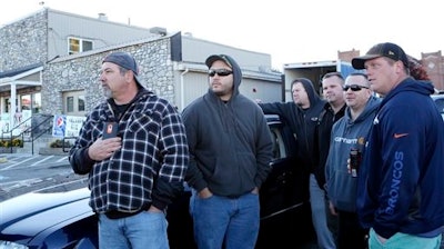 Norfolk Southern employees wait down the road to be let into work, as the company placed a hold on entering the railyard, after the shooting at FreightCar America Tuesday morning, Oct. 25, 2016. Police say a man fatally shot someone and wounded several others inside FreightCar America, a rail car manufacturing company, before apparently killing himself.