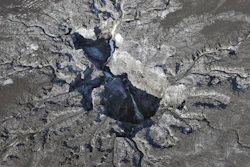Water continues to flow into a large sinkhole on the Mosaic Co. property shown in this aerial photo Thursday, Sept. 29, 2016, in Mulberry, Fla. Neighbors of the huge sinkhole sending cascades of contaminated water and fertilizer plant waste into Florida's main drinking-water aquifer are fearful and fuming that it took weeks for them to be notified about the disaster. Many are still waiting anxiously for results from tests for radiation and toxic chemicals in their well water.