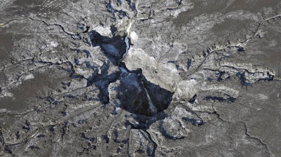 Water continues to flow into a large sinkhole on the Mosaic Co. property shown in this aerial photo Thursday, Sept. 29, 2016, in Mulberry, Fla. Neighbors of the huge sinkhole sending cascades of contaminated water and fertilizer plant waste into Florida's main drinking-water aquifer are fearful and fuming that it took weeks for them to be notified about the disaster. Many are still waiting anxiously for results from tests for radiation and toxic chemicals in their well water.