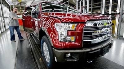 In this March 13, 2015, file photo, a worker inspects a new 2015 aluminum-alloy body Ford F-150 truck at the company's Kansas City Assembly Plant in Claycomo, Mo. U.S. safety regulators are investigating whether a recall of Ford F-150 pickup trucks for brake failures should be expanded to more model years. The probe covers about 282,000 pickups with 3.5-liter six-cylinder engines from 2015 and 2016.