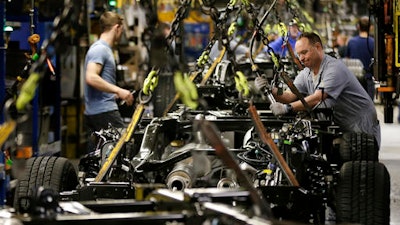 In this March 13, 2015, file photo, a worker prepares a chassis to receive an engine on a new aluminum-alloy body Ford F-150 truck at the company's Kansas City Assembly Plant in Claycomo, Mo. Ford Motor Co. is temporarily idling four North American plants in response to slowing consumer demand for new vehicles. The company has scheduled one-week closures in October 2016 for its plants in Kansas City, Mo., and Hermosillo and Cuatitlan, Mexico, and a two-week closure in Louisville, Ky.