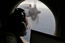 In this March 22, 2014 file photo, flight officer Rayan Gharazeddine scans the water in the southern Indian Ocean off Australia from a Royal Australian Air Force AP-3C Orion during a search for the missing Malaysia Airlines Flight MH370. A ship involved with the deep-sea sonar search for missing Malaysia Airlines Flight 370 is being fitted with equipment to examine several sonar contacts of interest on the remote seabed west of Australia, the Australian Transport Safety Bureau said on Wednesday, Oct. 19, 2016.
