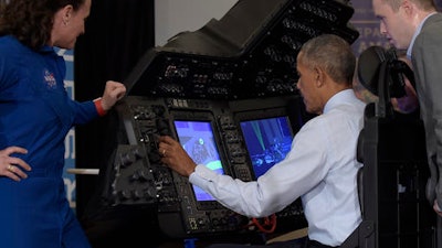 President Barack Obama sits in a flight simulator during a tour of innovation projects at the White House Frontiers Conference at University of Pittsburgh in Pittsburgh, Thursday, Oct. 13, 2016. NASA astronaut Dr. Serena Aunon-Chancellor, left, and Boeing Representative Daniel Nelson, right, watch. Obama was operating a spacecraft flight and docking simulator that replicates the training setup that NASA's commercial crew astronauts are using to prepare for future missions to the International Space Station.