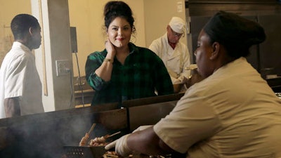 In this Wednesday, Sept. 28, 2016, photo, Olivia Colt, owner of catering company Salt & Honey, center, poses for photos as members of her cooking staff work in the kitchen in Berkeley, Calif. The campaign to give workers time off when they’re sick is picking up momentum. Before California enacted its law, Colt had given paid leave to her salaried managers as a way to retain employees in an industry with high turnover. Now, hourly employees get sick leave as well, accruing one hour for each 30 hours they work. Colt sees several benefits: She has less staff turnover, and her 20 workers take better care of their health.