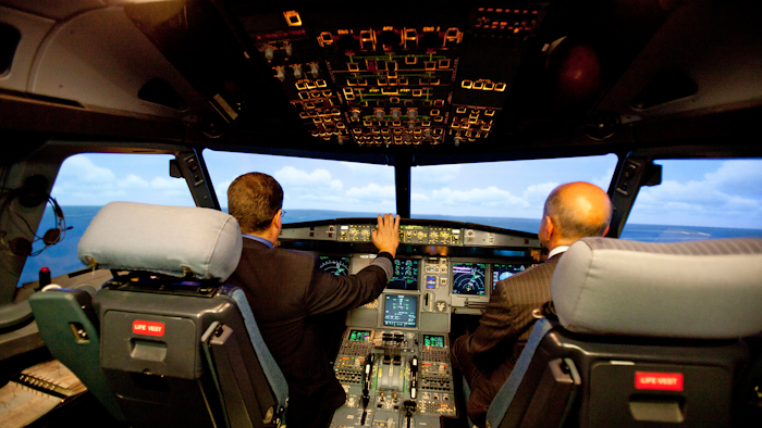 In this file photo, Jet Blue pilot, Captain Joe Devito, left, navigates a NextGen flight simulator with FAA Administrator Michael Huerta at a Jet Blue facility in Orlando.