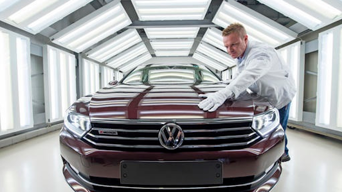 In this file photo, worker Maik Neubert checks a Passat Variant car during the visual inspection during a press tour at the plant of the German manufacturer Volkswagen Sachsen in Zwickau, Germany. Volkswagen has announced significant job cuts as it looks to recover from the emissions-rigging scandal first brought to light in 2015.