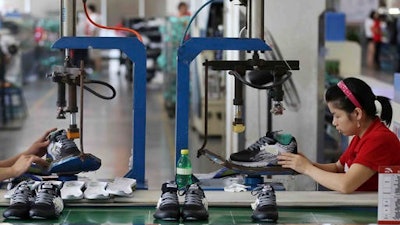 Workers assemble sneakers at a factory in Jinjiang city in southeast China's Fujian province. Private and official surveys show that China's factory activity rose to a two-year high in October 2016, suggesting the world's No. 2 economy is stabilizing.