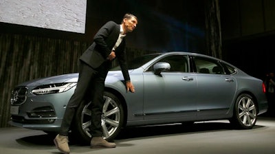 Thomas Ingenlath, Vice president of Volvo Cars design, shows a new S90 Volvo car in Shanghai, China, Wednesday, Nov. 2, 2016. Volvo Cars and its Chinese owner are revving up their profile as they focus on selling premium cars in world markets. The companies announced a strategy Wednesday that includes a new factory to make vehicles based on a new shared platform, including vehicles for Geely's new 'connected car' brand, Lynk & Co.