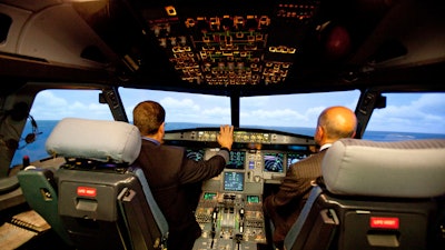 In this file photo, Jet Blue pilot, Captain Joe Devito, left, navigates a NextGen flight simulator with FAA Administrator Michael Huerta at a Jet Blue facility in Orlando.