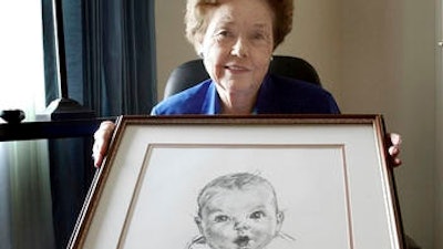 In this Feb. 4, 2004, file photo, Ann Taylor Cook, poses at her Tampa, Fla., home with a copy of her photo that is used on all Gerber baby food products. Gerber says Cook turned 90 on Sunday, Nov. 20, 2016.