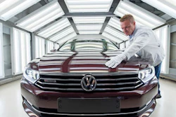 In this file photo, worker Maik Neubert checks a Passat Variant car during the visual inspection during a press tour at the plant of the German manufacturer Volkswagen Sachsen in Zwickau, Germany. Volkswagen has announced significant job cuts as it looks to recover from the emissions-rigging scandal first brought to light in 2015.