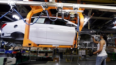 In this file photo, a Buick Verano is assembled at General Motors' Orion Assembly plant in Orion Township, Mich. The Federal Reserve says manufacturing production improved 0.2 percent last month, matching the gain in September.