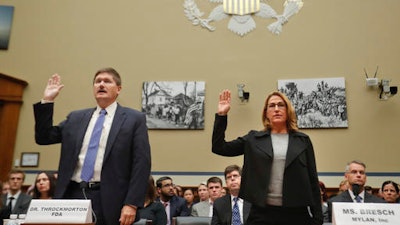 In this Wednesday, Sept. 21, 2016 file photo, Mylan CEO Heather Bresch, right, and Dr. Doug Throckmorton, deputy director, Center for Drug Evaluation and Research, Food and Drug Administration (FDA), are sworn in on Capitol Hill in Washington, prior to testifying before the House Oversight Committee hearing on EpiPen price increases. Bresch defended the cost for life-saving EpiPens, signaling the company has no plans to lower prices despite a public outcry and questions from skeptical lawmakers.