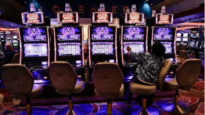 In this Oct. 3, 2014, file photo, a visitor to the Resorts World Casino at the Aqueduct racetrack plays an electronic slot machine, in the Queens borough of New York. The casino said on Nov. 3, 2016, that a woman who was shown that she won nearly $43 million on a penny slot in August 2016 actually won $2.25.