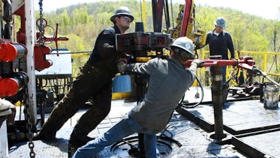 In this April 23, 2010 photo, workers move a section of well casing into place at a Chesapeake Energy natural gas well site near Burlington, Pa., in Bradford County. President-elect Donald Trump has not minced words about his approach to environment and energy policy: He loathes regulation, and wants to increase the use of coal, offshore drilling and fracking.