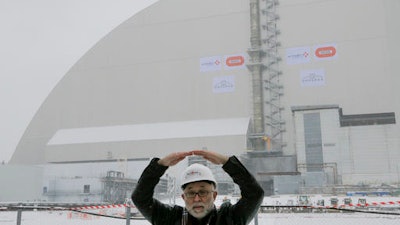 A worker explains a structure of an arch-shaped enclosure in Chernobyl, Ukraine, Tuesday, Nov. 29, 2016. The gargantuan arch-shaped enclosure has begun slowly moving towards the exploded Chernobyl nuclear reactor, in what represents a significant step toward liquidating the remains of the world's worst nuclear accident.