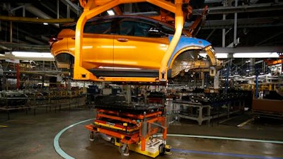 In this Nov. 4, 2016, photo, a battery pack moves in to align with a Chevrolet Bolt EV for installation during a tour of the General Motors Orion Assembly plant in Orion Township, Mich. What General Motors wants consumers to see in the Bolt is the electric car that will cater to their everyday needs: commuting, shopping, transporting children and gear, all on one charge of its battery. It's the first electric car to get more than 200 miles per charge and fit most buyers' budgets.