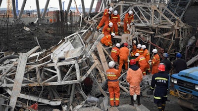 In this Thursday, Nov. 24, 2016 file photo released by Xinhua News Agency, rescue workers look for survivors after a work platform collapsed at the Fengcheng power plant in eastern China's Jiangxi Province. Chinese authorities said they detained 13 people over the collapse of scaffolding at a power plant construction site that killed 74 workers in one of China's most serious industrial accidents in years.