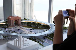 A woman takes a photograph of a model of the Hyperloop One project during a news conference in Dubai, United Arab Emirates, Tuesday, Nov. 8, 2016. The futuristic city-state of Dubai announced a deal on Tuesday with Los Angeles-based Hyperloop One to study the potential for building a line linking it to the Emirati capital of Abu Dhabi.
