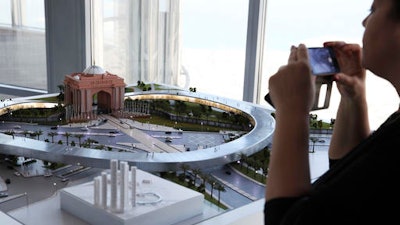 A woman takes a photograph of a model of the Hyperloop One project during a news conference in Dubai, United Arab Emirates, Tuesday, Nov. 8, 2016. The futuristic city-state of Dubai announced a deal on Tuesday with Los Angeles-based Hyperloop One to study the potential for building a line linking it to the Emirati capital of Abu Dhabi.