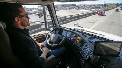 In this Thursday, Aug. 18, 2016, file photo, Matt Grigsby, senior program engineer at Otto, takes his hands off the steering wheel of a self-driving, big-rig truck during a demonstration on the highway, in San Francisco. Uber's self-driving startup Otto developed technology allowing big rigs to drive themselves. After taking millions of factory jobs, robots could be coming for a new class of worker: people who drive for a living.