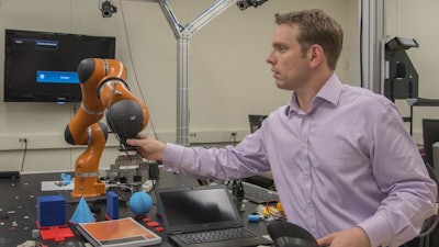 NIST engineer Jeremy Marvel adjusts a robotic arm used to study human-robot interactions. According to a NIST economic study on advanced robotics and automation -- one of four reports on advanced manufacturing -- Marvel's work is the type of research needed to fortify and facilitate this emerging field.