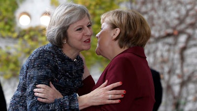 Britain's Prime Minister Theresa May, left, is welcomed by German Chancellor Angela Merkel prior to a meeting of the government heads of Germany, France, Italy, Spain and Britain with U.S. President Obama in the chancellery in Berlin, Germany, Friday, Nov. 18, 2016.